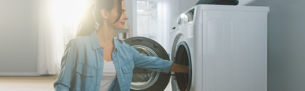 Woman reaching into a dryer.