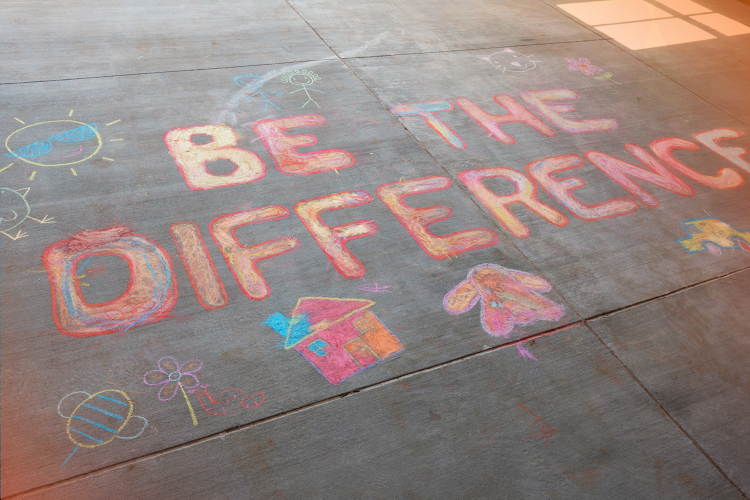 sidewalk chalk art reads 'be the difference'