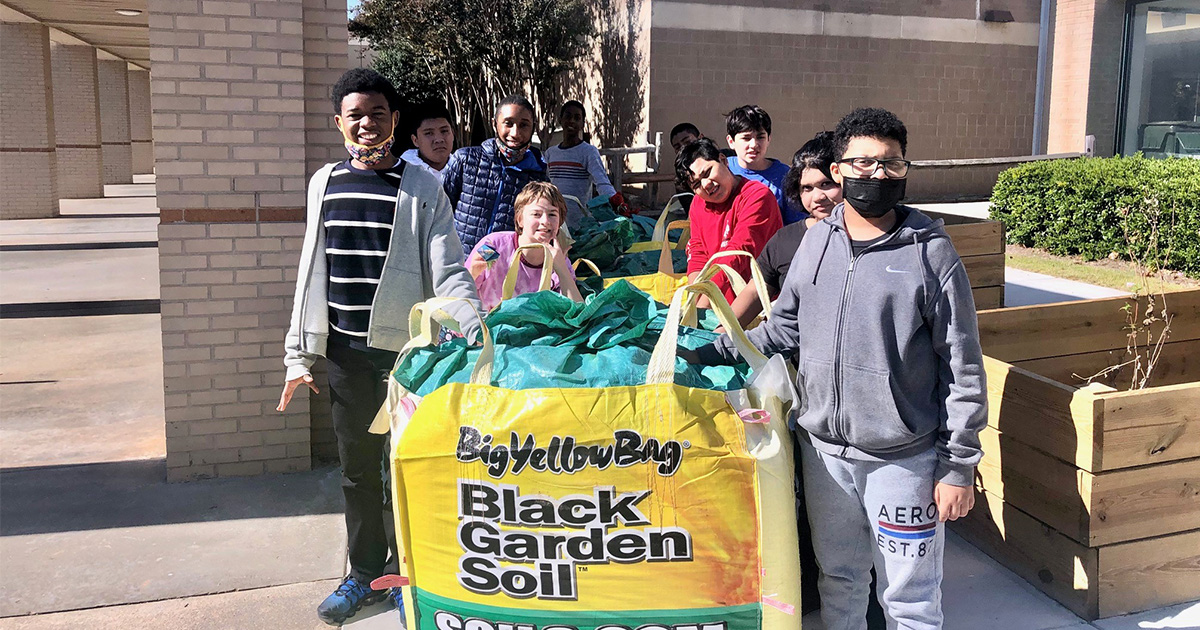 Radloff Middle School students pose with a giant bag of soil purchased with some of 2022’s Gas South STEAM funding that helped finance their Sustainable Food Systems project.