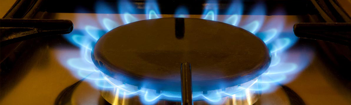 Blue natural gas flame coming from a natural gas stove top.