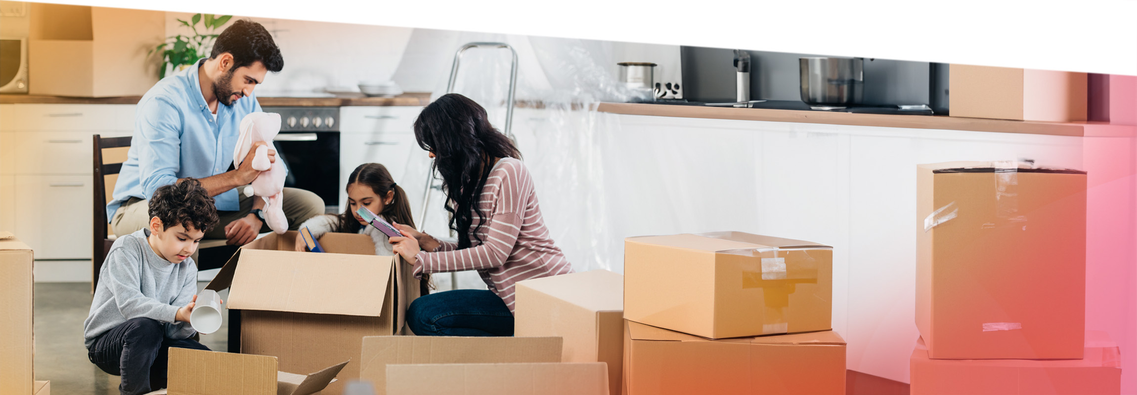 A woman moving into her new home looks happy as she carries a laundry basket full of household items up the stairs